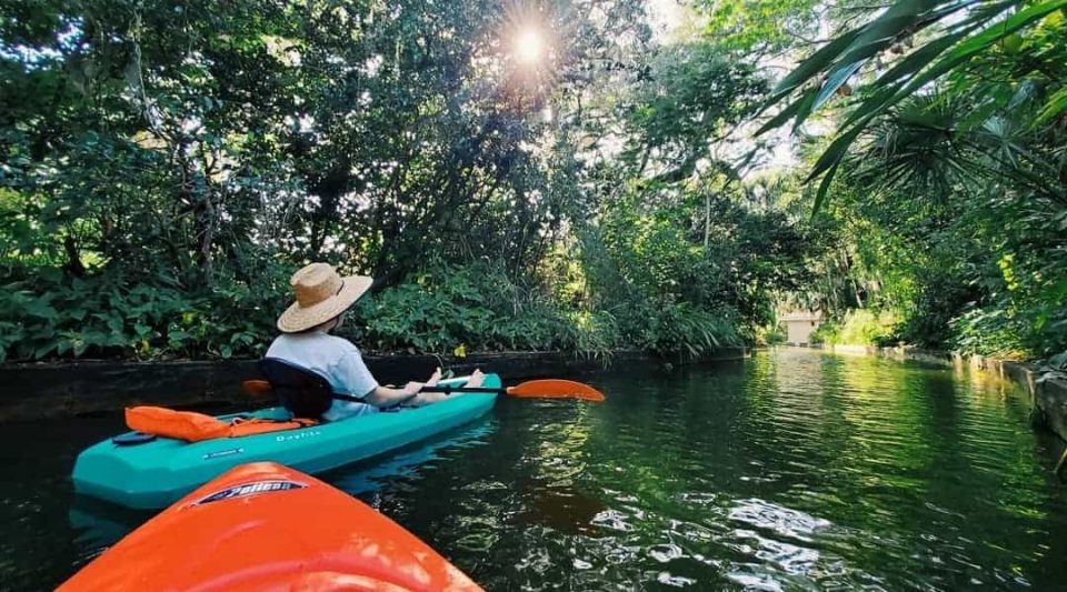 Dean Keeley kayaking through a river, surrounded by tropical greenery.